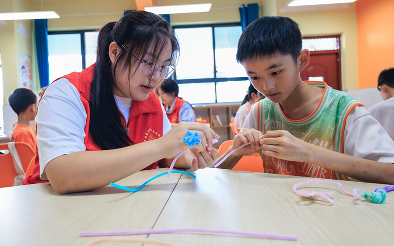 郧西县城关镇王家坪村红军小学爱心托管班的孩子在志愿者带领下做手工。邹景根摄